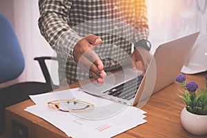 Office table with businessman holding handshake