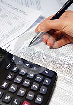 Office table with calculator, pen and accounting document