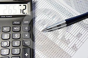 Office table with calculator, pen and accounting document