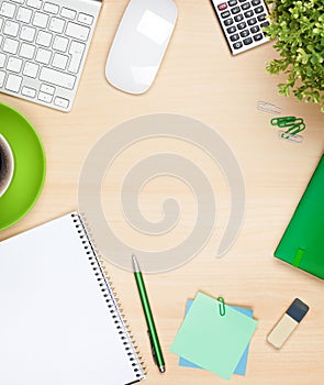 Office table with coffee cup, computer and flower