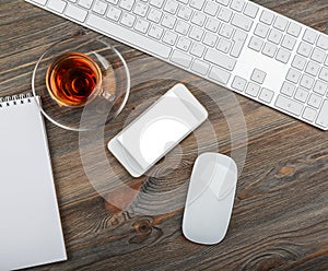 Office table with computer keyboard and cup of tea