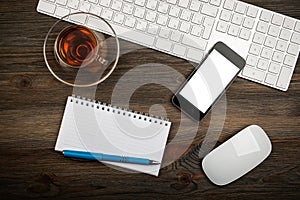 Office table with computer keyboard and cup of tea