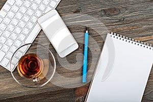 Office table with computer keyboard and cup of tea