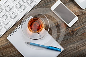 Office table with computer keyboard and cup of tea