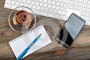 Office table with computer keyboard and cup of tea