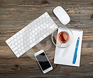 Office table with computer keyboard and cup of tea