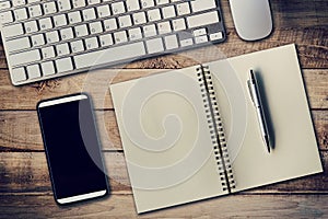 Office table with computer, phone, notebook and pen. photo