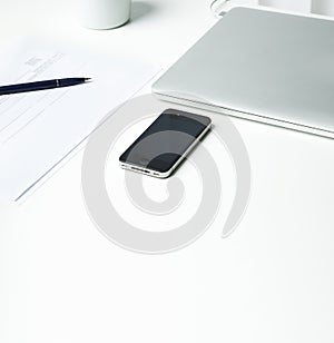 Office table with computer, supplies and coffee cup. Top view wi