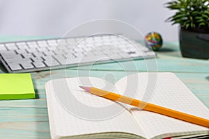 Office table desk with set of colorful supplies, flower on blue