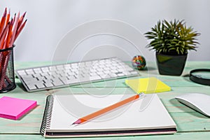 Office table desk with set of colorful supplies, flower on blue background