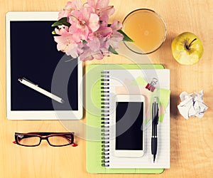 Office table with digital tablet, smartphone, reading glasses and healthy breakfast. View from above