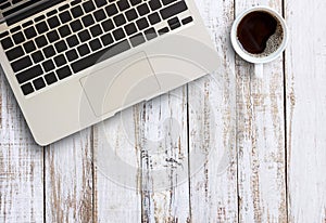 Office table with laptop computer and coffee cup.