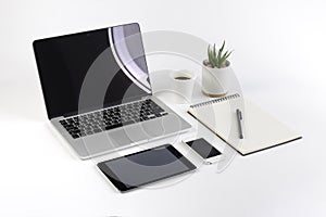 Office table with laptop computer, notebook, digital tablet and smartphone on white background