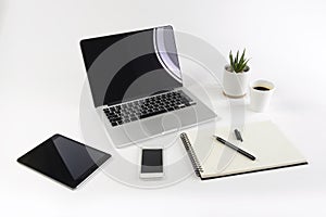 Office table with laptop computer, notebook, digital tablet and smartphone on white background