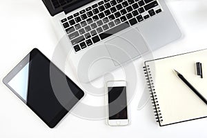 Office table with laptop computer, notebook, digital tablet and smartphone on white background