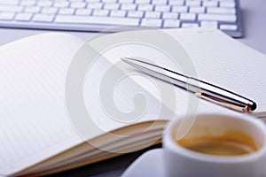 Office table with notebook, computer keyboard,, cup of coffee, tablet pc. copy space.