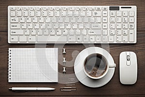 Office table with notepad, computer and coffee cup