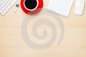 Office table with notepad, computer and coffee cup