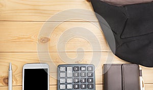 Office table with pen, wallet, calculator, suit and smart-phone. View from above with copy space.