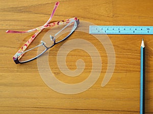 Office table with pencil, ruler and eye glasses.