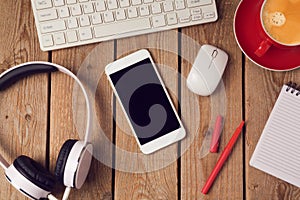 Office table with smartphone and headphones. Business workplace or workspace concept.