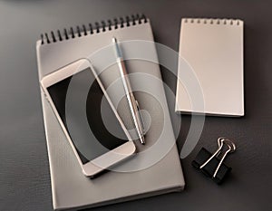 Office tools and gadgets symbolizing an assistant\'s role, featuring items like a notebook, pen, and smartphone, representing photo