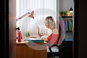 Office Woman Holding Dog During Skype Conference Call photo