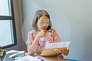 Office woman reading financial document next to the window