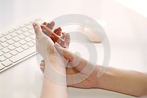Office woman using massage stick for Stimulate circulation, decrease muscle pain and tension hands and fingers to sooth the strain