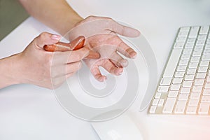 Office woman using massage stick for Stimulate circulation, decrease muscle pain and tension hands and fingers to sooth the strain