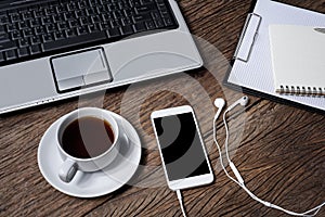 Office wooden desk with pen, notepad, coffee cup, smartphone and