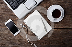 Office wooden desk with pen, notepad, coffee cup, smartphone and