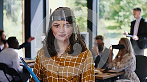 Office work after COVID-19. Portrait of young happy 30s Caucasian business woman in plastic face shield slow motion.