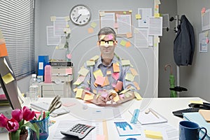 Office worker covered with stick notes