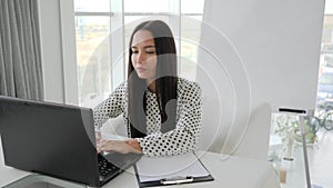 Office worker crumples documents and Ñloses laptop at desk, beautiful girl manager shuts laptop in white office