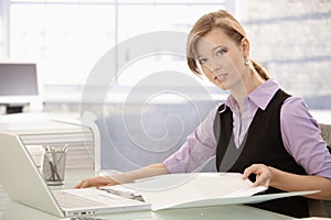 Office worker doing paperwork at desk