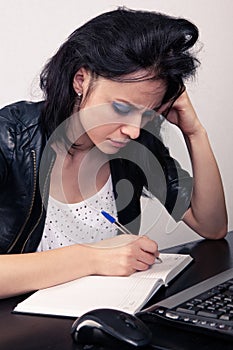 Office worker girl working on a computer and does records in a diary