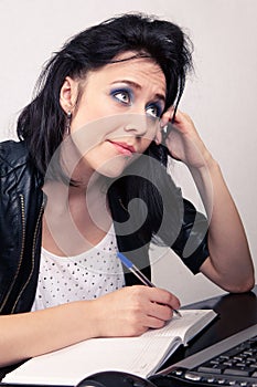 Office worker girl working on a computer and does records in a diary