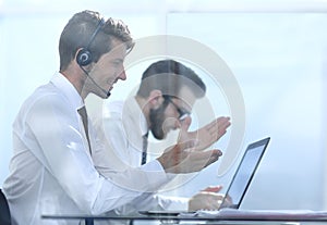 Office worker with headset on while having video conference