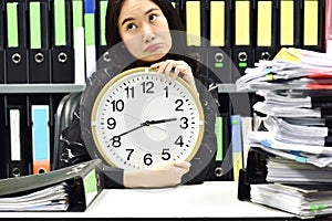 Office worker holding a clock, Working overtime and lot of work