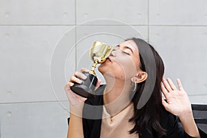 Office worker kissing trophy. A business woman or Employees is h