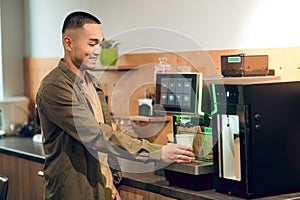 Office worker making a caffeinated beverage in the company kitchen