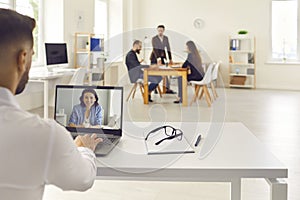 Office worker making video call on laptop and talking to colleague, client or online business coach