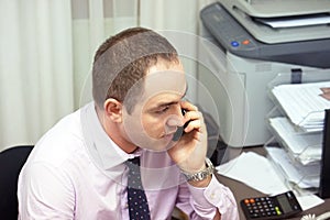 Office worker man answers the call. Businessman talking on phone at work