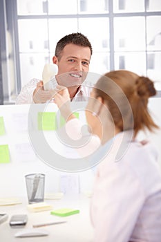 Office worker passing phone to colleague