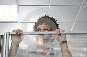 Office Worker Peering Over Cubicle Wall photo