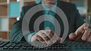 Office worker in plaid jacket blue shirt fast typing on computer keyboard