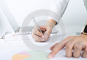 Office worker is pointing and analyzing paper chart infomation