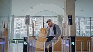 Office worker running entrance office with automatic gates talking cellphone.