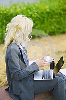 Office worker secretary woman writing on a piece of paper in a notebook. Businesswoman working outside on the street